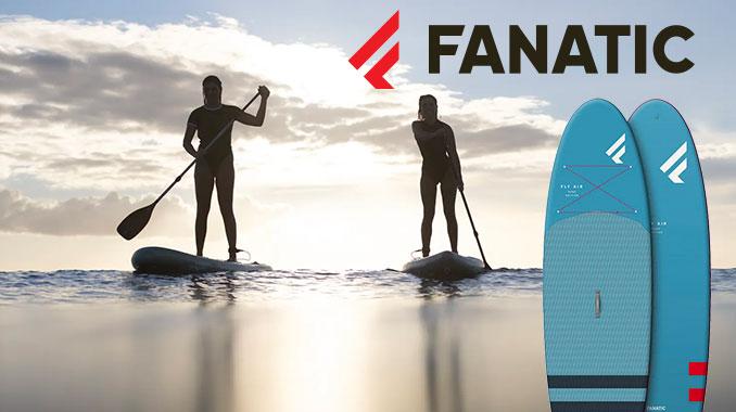 a photograph of two people are standing on surfboards in the water